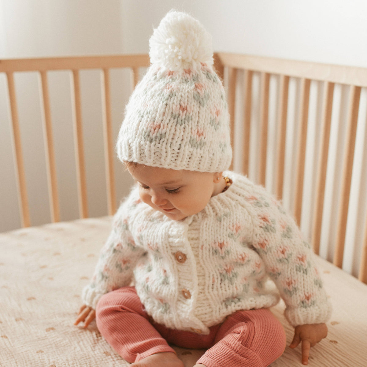 Baby in a knit sweater and pom hat