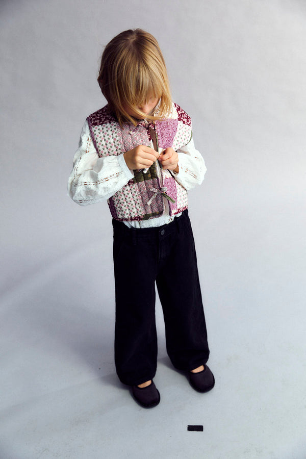 5 year old Child wearing the Melba Waistecoat and black pants on a plain background rented from the new society
